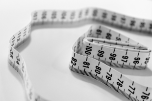A close up photo of a rolled up tape measure.