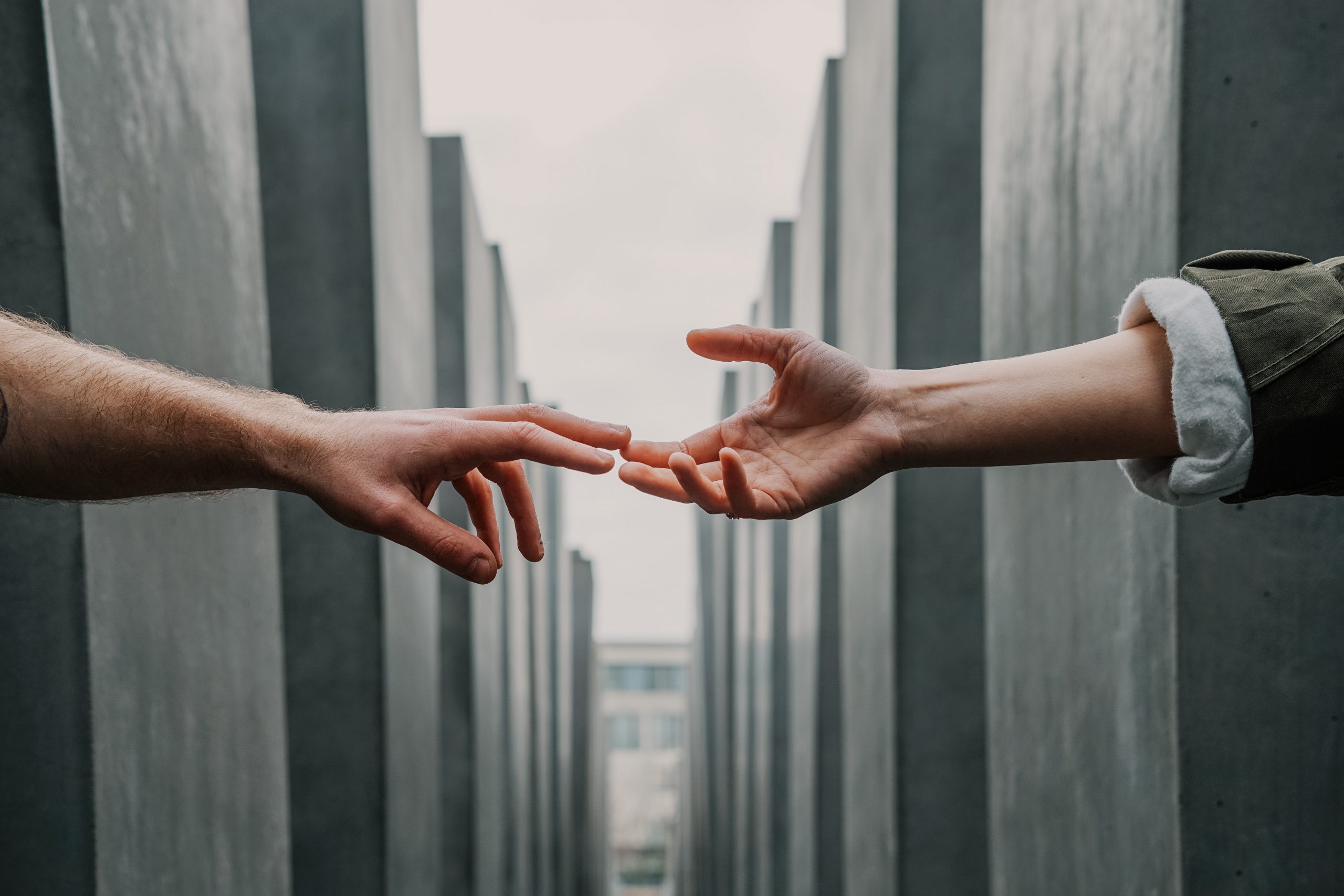 A man and a woman reaching out their hands to touch.